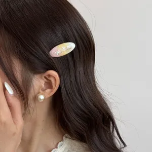 Ocean style shell oval hair clip for women, pink yellow gradient cute side hairpin accessory.