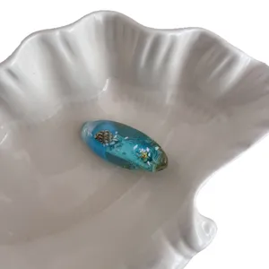 Ocean blue resin hair clip with cute shell and starfish elements, versatile side accessory.