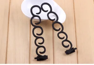 Détail d'accessoire de coiffure tresse cheveux noir en forme de S structure spirale.