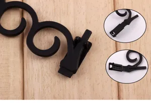 Gros plan détaillé du mécanisme noir en S pour tresser les cheveux, montrant la structure.