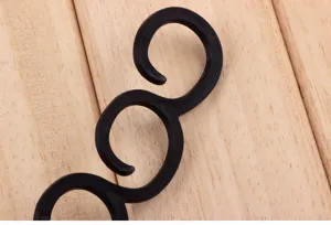 Vue détaillée de l'outil de tressage de cheveux noir en forme de S pour un style créatif.