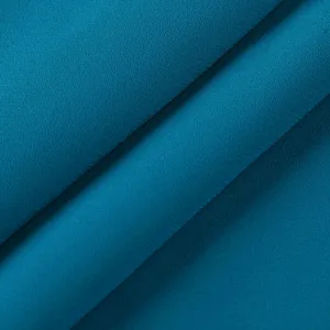 Close-up of dark teal fabric texture, fine grainy surface, soft and smooth material detail.