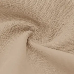 Close-up detail of solid beige fabric texture, showing fine weave and soft drape.