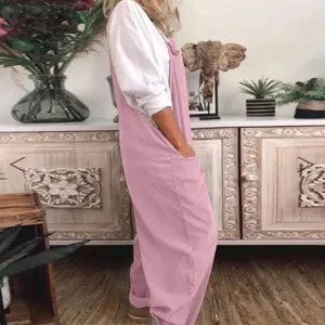 Detail view of casual loose pink overalls paired with a white top, indoor scene display.