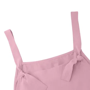 Close-up detail of women's pink casual overalls shoulder strap with cute side bow design.