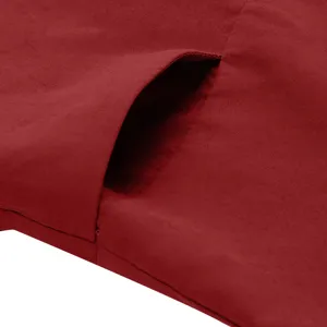 Close-up detail shot of red casual trousers pocket, highlighting fine stitching and fabric texture.