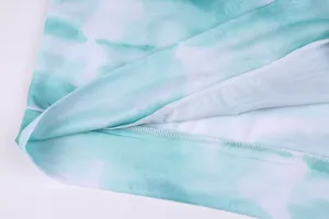 Close-up detail of women's blue tie-dye sweatshirt hem, showing soft fabric and neat stitching.