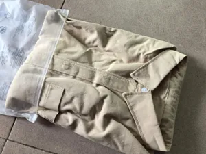 Detailed view of folded khaki long sleeve cotton mens casual shirt with button and pocket