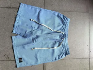 Primer plano de pantalones cortos casuales azul claro para hombre con cordón y lino suave.