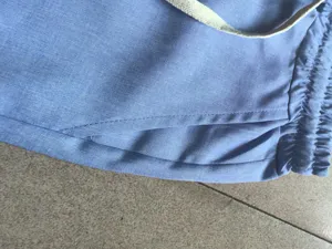 Primer plano detalle de pantalón corto casual para hombre azul claro con cintura elástica.