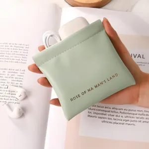 Pochette de rangement auto-fermante portable pour petits objets et écouteurs vert clair.