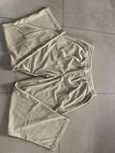 Close-up detail of men's corduroy straight casual pants featuring ribbed texture and drawstring.