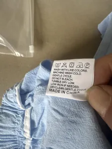 Detail shot of men's casual cotton-linen trousers showing the inner wash care label and fabric.