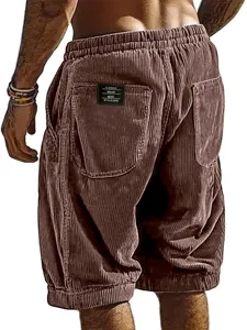 Detailed view of men's brown corduroy shorts back pocket label and textured fabric.