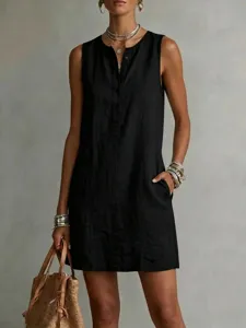 Sleeveless black linen dress featuring button front, relaxed fit, and side pockets.