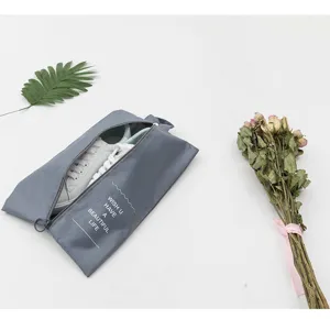 Detail view of portable travel shoe storage bag with zipper and handle for sneaker organization.