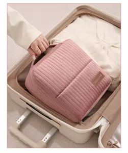 Detailed view of pink quilted travel cosmetic bag placed inside suitcase, showing large capacity.