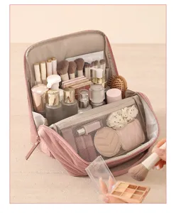 Close-up of pink standing cosmetic bag featuring multiple brush slots and transparent mesh pockets.