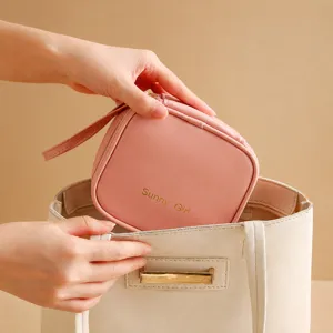 Primo piano del dettaglio della borsa rosa portatile per assorbenti in morbida pelle.