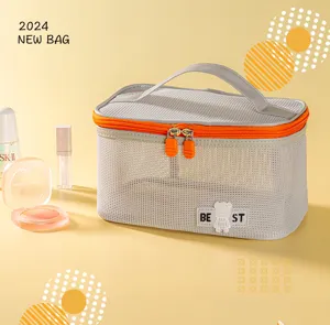 Detailed view of grey mesh toiletry bag featuring orange zipper and convenient carry handle.