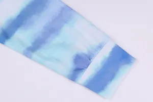 Close-up detail of women's long sleeve top with blue and white tie-dye gradient fabric.