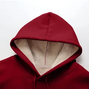 Primo piano dei dettagli della felpa con cappuccio rosso scuro con morbida fodera sherpa.
