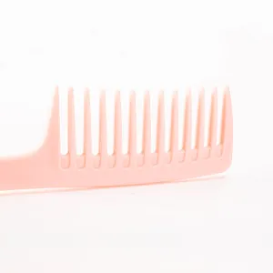 Peigne à cheveux rose en plastique à dents larges pour coiffage et usage quotidien.