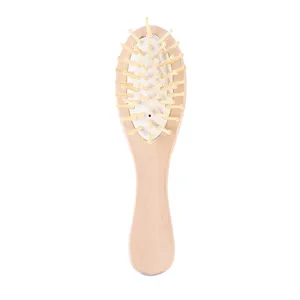 Vue de détail rapproché du mini peigne de massage pneumatique en bois avec des picots lisses.