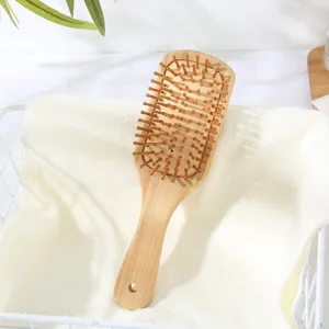 Spazzola per capelli con cuscino d'aria in bambù naturale e perni flessibili per uso quotidiano.