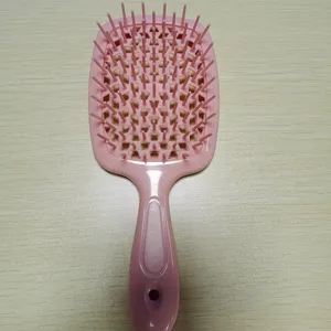 Détail de brosse à cheveux creuse rose, design en résille pour démêlage humide et sec.