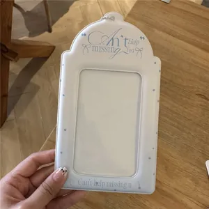 Gros plan du porte-carte photo blanc avec des pois bleus et un joli texte en anglais.