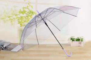 Primer plano de paraguas transparente con mango morado en un entorno decorativo de mesa.