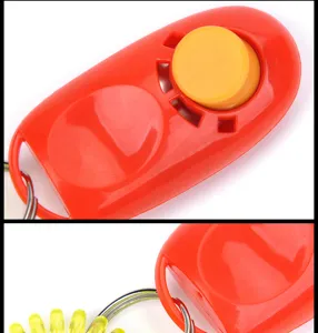 Dettagli in primo piano del clicker per addestramento animali rosso e giallo con cinturino.