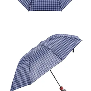 Detail shot of a compact three-fold folding umbrella featuring a classic blue plaid pattern.
