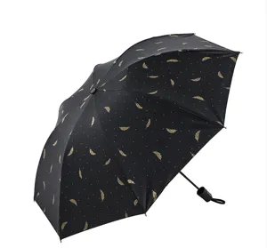 Paraguas plegable negro portátil con patrón de plumas doradas, protección UV parasol negro