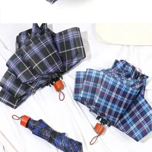 Detail view of folding plaid umbrellas featuring classic check patterns and wooden handles.