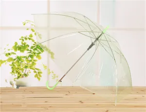 Plano detalle de paraguas transparente claro con mango curvo verde y estructura sólida.