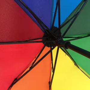 Close up view of colorful rainbow umbrella interior structure, showing black ribs and joints.
