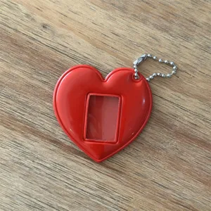 Primo piano dettagliato del portachiavi portafoto rosso a forma di cuore con finestra.