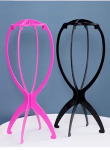 Nahaufnahme der zusammenklappbaren Kunststoff-Perückenständer in Rosa und Schwarz zur Pflege.