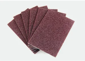 Detail view of brown abrasive scouring pads, showing textured surface and sponge material.