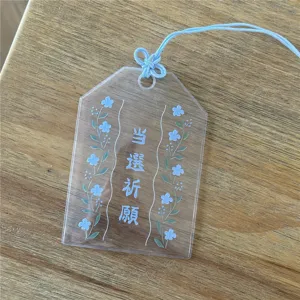 Transparent PVC Omamori card sleeve detail with blue hanging cord and Japanese blessing print.