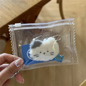 Clear glitter PVC storage bag detail showing plush cat keychain and card holder inside.