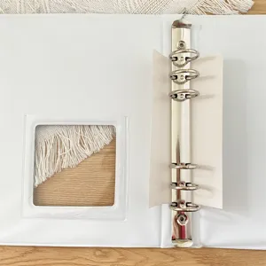 Detail view of white loose leaf binder ring mechanism and transparent window, close up.