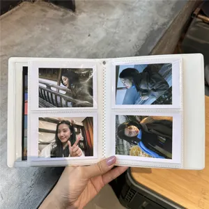Close-up detail of white 3-inch photocard storage album with transparent pockets and card inserts.