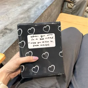 Detailed shot of mini photo card binder, black cover with white hearts and cute English text.