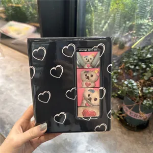 Detailed view of the black heart-patterned photocard binder, showing the front window pocket.