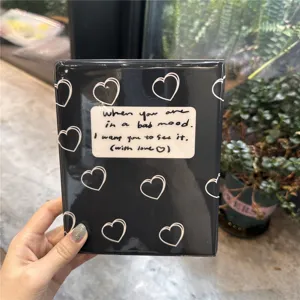 Black photocard binder detail shot, cute white heart pattern mini album collect book.