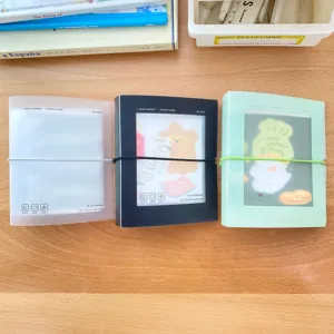 Detailansicht von transparenten 3-Zoll Fotokarten Ordnern mit Gummibändern auf Holztisch.