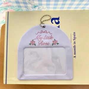 Vue détaillée du porte-photocarte violet avec nœud et roses pour mini cartes polaroid.